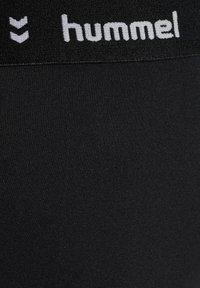 Schwarze Sportshorts mit einem strukturierten Bund, der den weißen Markennamen "hummel" zeigt. Der Stoff ist glatt, dehnbar und leicht.