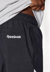 Sorte Reebok shorts i et tekstureret, let materiale. Har en elastisk talje og en baglomme. Fremtrædende logo i hvid.