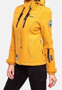 Veste jaune avec capuche, fermeture éclair à l'avant et accents noirs. Comprend plusieurs poches et détails de logo sur les manches. Tissu doux et texturé.