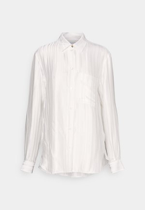 Λευκό πουκάμισο μακρύ μανίκι από σατινέ ύφασμα με κατακόρυφη υφή ριπ, κολάρο με κουμπιά και μία τσέπη στο στήθος. Χρυσό κουμπί διακοσμητικό.