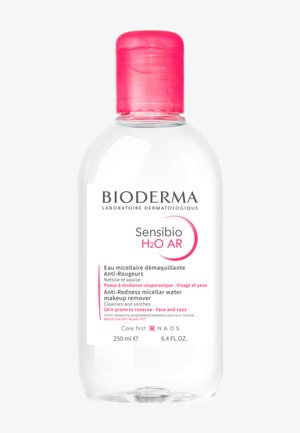Bottiglia trasparente di plastica di acqua micellare Bioderma Sensibio H2O AR, con tappo rosa ed etichetta bianca con testo nero e rosa. 250 ml.