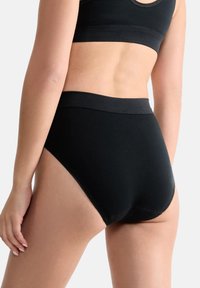 Hoge taille zwarte katoenen slips met naadloze randen, een zachte band en een gladde textuur, ontworpen voor comfort en volledige bedekking.
