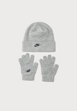 Lysegråt strikket vintersæt med en hue og et par handsker, hver med et sort Nike-logo på en ensfarvet baggrund.