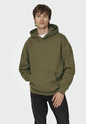 Olive green hoodie with a front pocket, drawstring hood, and ribbed cuffs. Soft fabric, relaxed fit, and minimal design. Worn with dark jeans.