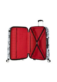 Valigia rigida bianca e nera con design in stile cartone animato. L'interno presenta un rivestimento rosso brillante con più scomparti e cinghie.