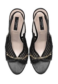 Schwarze Slingback-Schuhe mit einem Obermaterial aus Netzgewebe in Wabenstruktur, einer Zehenkappe aus Leder und einem goldenen Kettenakzent an der Vorderseite.