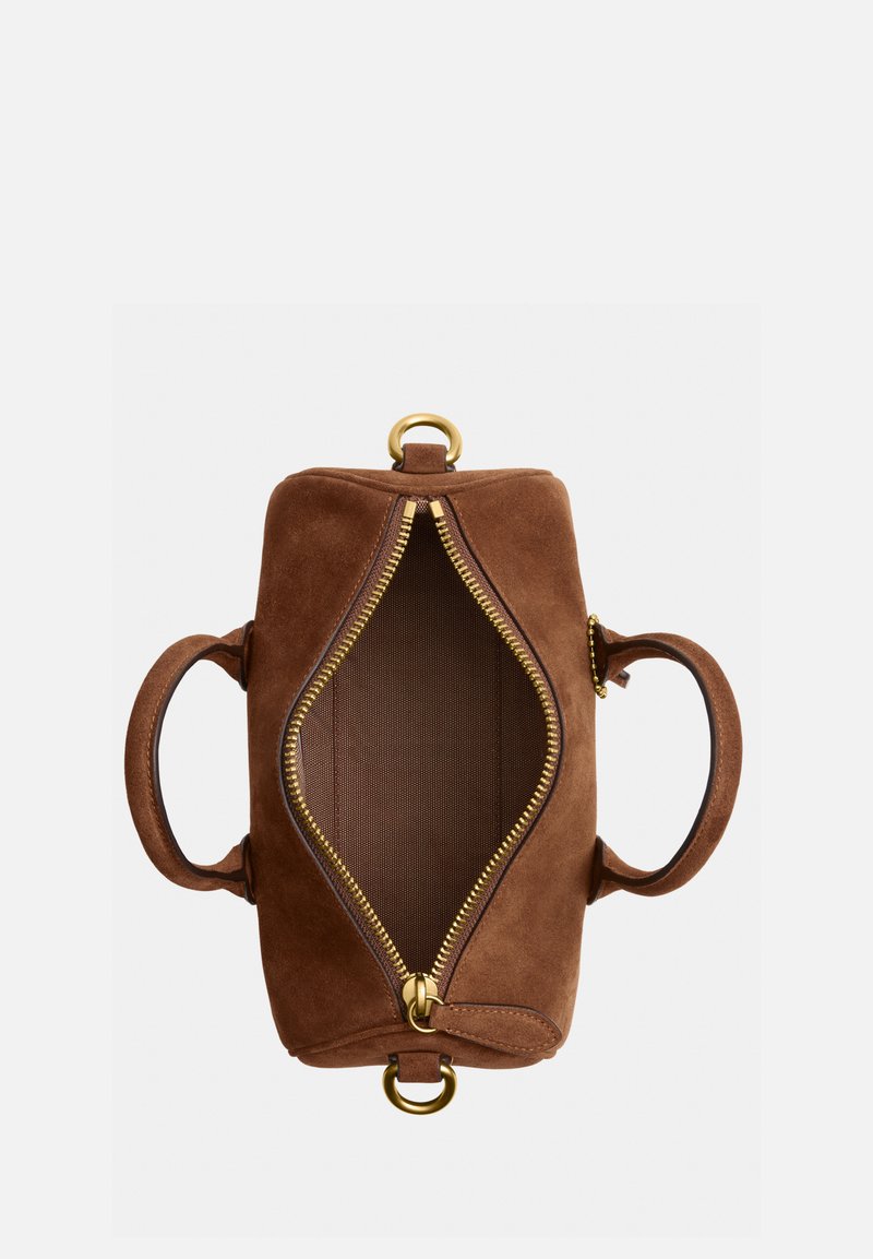 Sac à main en daim marron avec fermeture éclair supérieure ouverte, montrant l'intérieur vide, deux poignées latérales et des anneaux métalliques dorés à chaque extrémité.