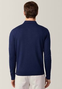 Granatowy sweter polo z długim rękawem, z teksturowanym splotem, klasycznym kołnierzykiem i ściągaczami na rękawach. Prosty, dopasowany fason bez zdobień.