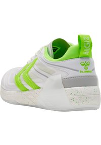 Chaussure de sport blanche avec des accents vert fluo, en tissu en maille, semelle texturée et semelle intermédiaire mouchetée. Présente un logo au niveau du talon et une étiquette de marque sur le col.