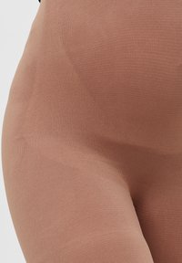 Ugjennomsiktige, elastiske strømpebukser i en dempet rosefarge. Glatt tekstur med ribbede detaljer rundt midjen og lårene for ekstra støtte.