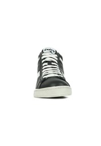 Sneaker in pelle nera con dettagli bianchi, punta tonda, lacci bianchi e suola in gomma testurizzata. Caratterizzato da un design minimalista e logo sulla linguetta.