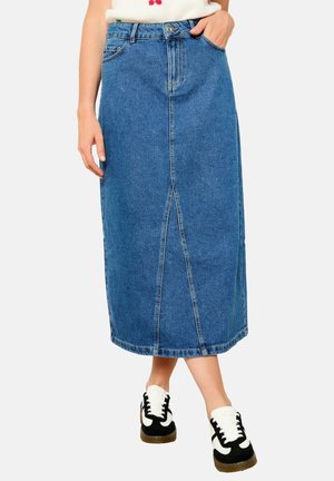 Vaaleansininen denim-mittapituinen hame, jossa on edessä halkio, viisi taskua ja näkyvä vyötärönauha. Yhdistetty mustiin ja valkoisiin lenkkareihin.