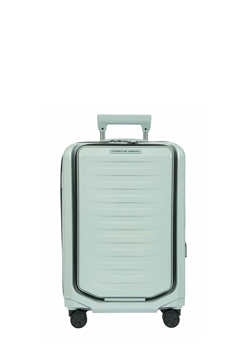 Valise rigide de cabine gris clair avec quatre roues, poignée télescopique et logo "Porsche Design" à l'avant.