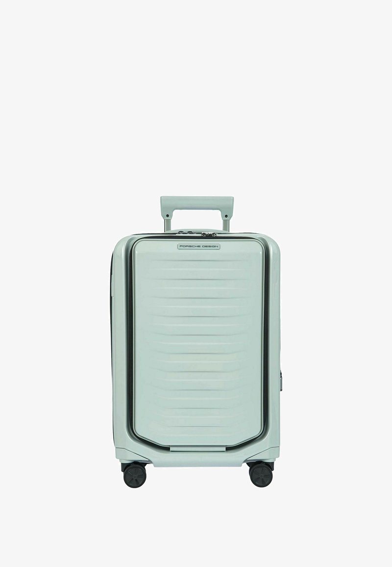 Valise rigide de cabine gris clair avec quatre roues, poignée télescopique et logo "Porsche Design" à l'avant.