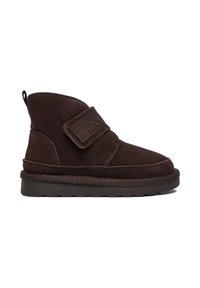 Brązowy zamszowy botek na kostkę z regulowanym paskiem na rzep, okrągłym noskiem i teksturowaną gumową podeszwą, z przeszyciami wzdłuż szwów.