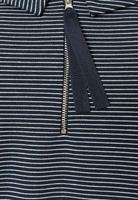 Navy- und weiß gestreuter Stoff mit einem Reißverschluss, der einen textilen Zippergriff und eine weiche Textur aufweist.