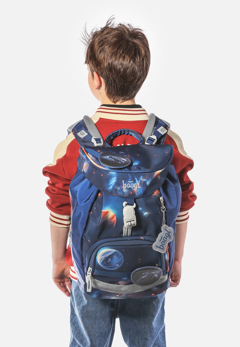 Modrý batoh s vesmírným motivem, který obsahuje planety, nastavitelné šedé popruhy, přední kapsu a klipové uzavření. Navržen pro mladé uživatele.