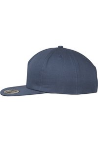 Navy blue cap with a flat brim, made from fabric with a smooth texture. Features six ventilation eyelets and a circular logo patch on the brim.