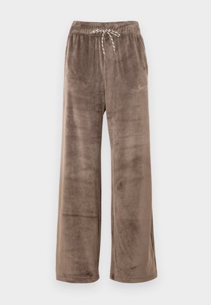 Pantalon large en velours marron avec taille élastique et cordon rayé, avec un petit logo Nike doré sur la cuisse droite.