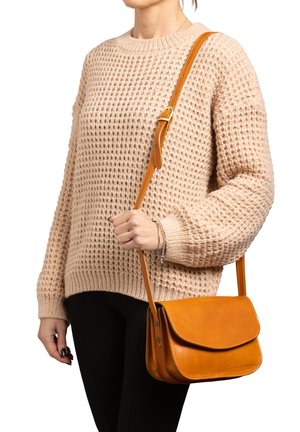 Sac en cuir tan à bandoulière avec une fermeture à rabat, présente une texture lisse, des détails de couture et une bandoulière ajustable.