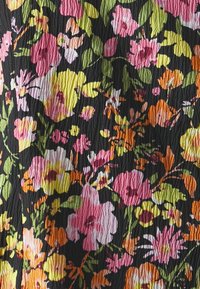 Un tessuto stropicciato presenta un motivo floreale con fiori rosa, arancioni e gialli su uno sfondo nero, mostrando un aspetto texturizzato.