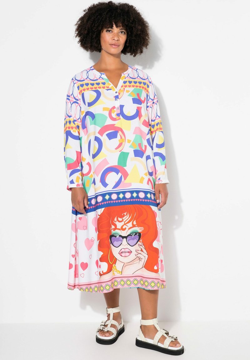 Robe colorée à manches longues en tissu léger, avec des motifs abstraits et une illustration graphique d'une femme aux cheveux roux et portant des lunettes de soleil.