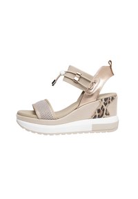 Beige wedge sandals with a mesh upper and animal print detail. Features a metallic ankle strap and a white rubber sole.