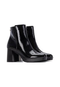 Botas de tobillo de cuero negro con un acabado brillante, tacón cuadrado grueso, puntera redondeada y acento dorado en la parte posterior. Textura suave en todo el zapato.