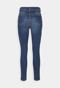 Smala jeans i mörkblå denim, med hög midja, bakfickor och subtila sömnadsdetaljer. Slät textur, åtsittande design.