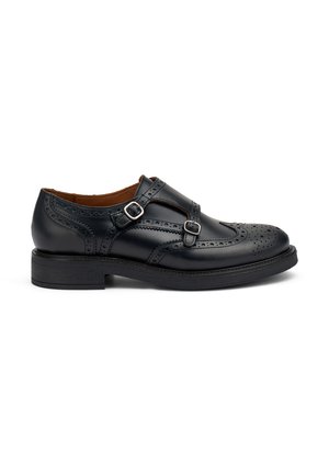 Scarpa in pelle nera con dettagli brogue, due cinturini regolabili con fibbie argentate e suola in gomma nera. Design classico, tacco basso.