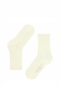 Calze in cotone color crema con texture liscia, design a lunghezza caviglia e punta rinforzata; contrassegnate con "FALKE" e informazioni sulla taglia.