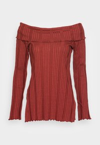 Off-the-shoulder top in rust color, ribbed texture, long sleeves with flared cuffs, subtle wavy hem, made from stretch fabric.