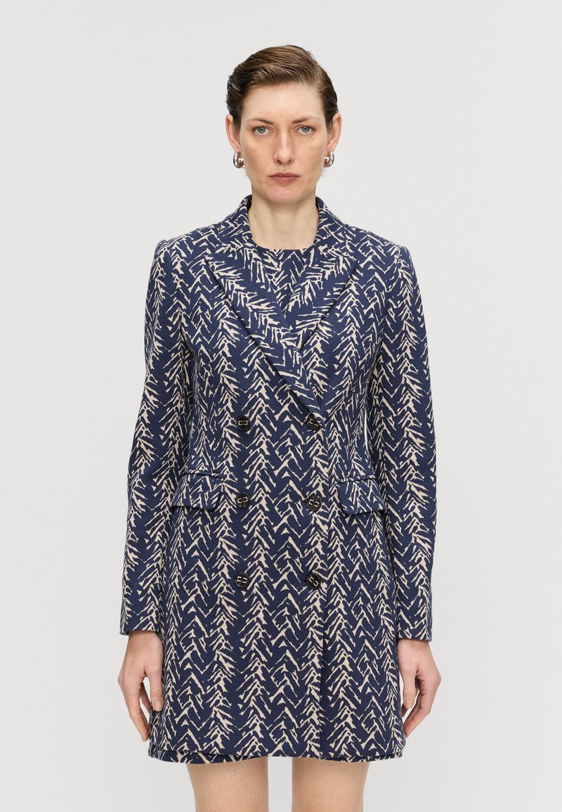 Sacou bleumarin cu două rânduri de nasturi, având un model cu frunze în bej, dotat cu guler tip rever, două buzunare frontale și nasturi decorativi.
