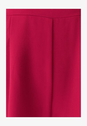 Primer plano de una tela roja suave y vibrante que presenta una costura vertical y una textura suave, adecuada para prendas de vestir o tapicería.