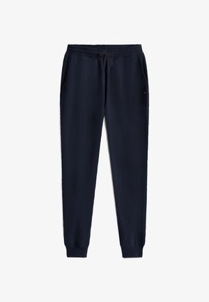 Marineblå sweatpants med elastisk taljebånd og snøre. Har sidelommer og ribkant ved benenden. Glat stofstruktur.