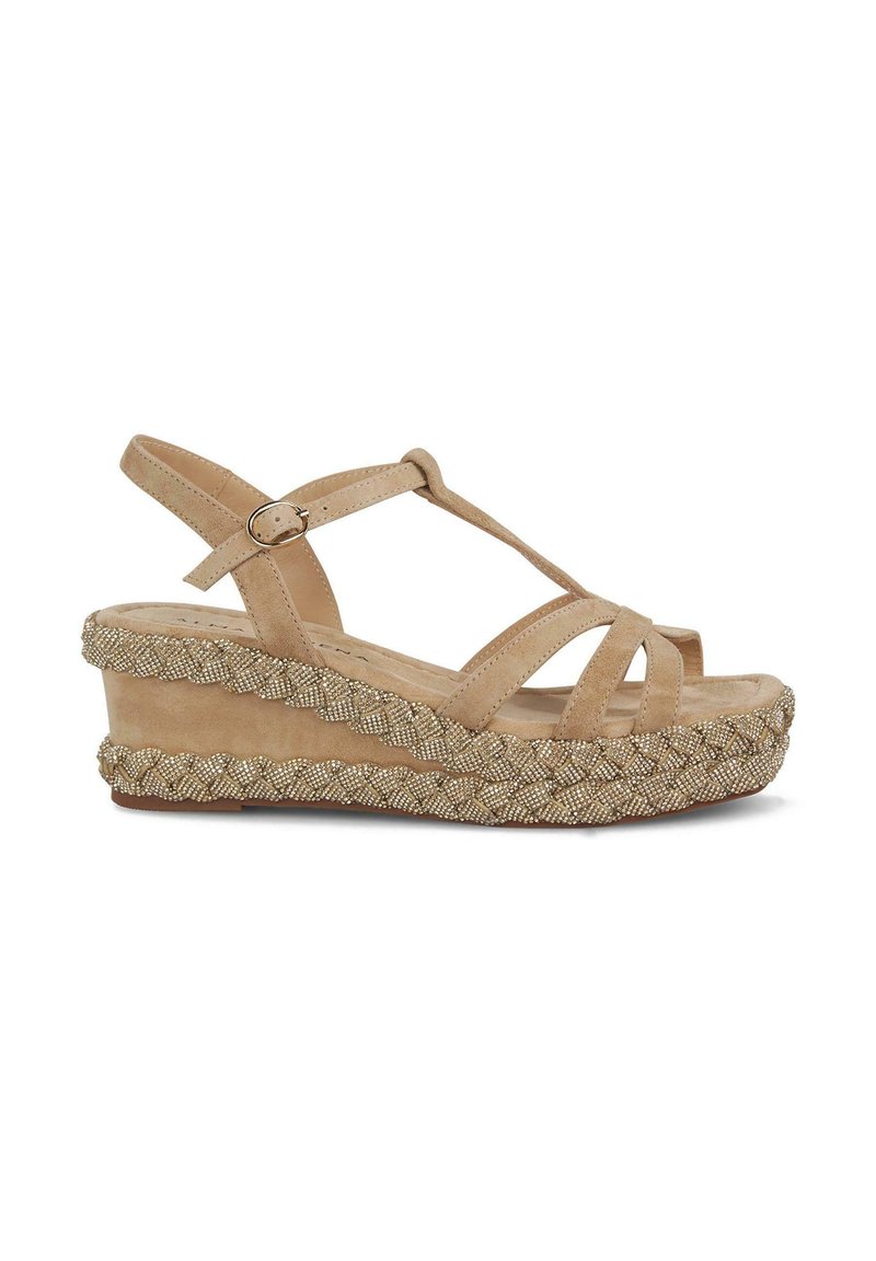 Sandalias de cuña beiges con una suela trenzada estilo alpargatas, con tiras entrelazadas y cierre de hebilla en el tobillo. Detalles de superficie texturizada.