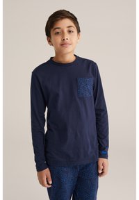 Námornícka dlhá rukávová bavlnená tričko s textúrovanou modrou grafickou vreckom. Skombinované s modrými vzorovanými pyžamovými nohavicami s výraznými písmenami.