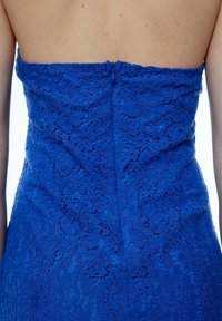 Blaues Spitzenkleid mit schmaler Passform, blumigen Mustern und einem verdeckten Reißverschluss auf der Rückseite. Das strukturierte Material hat ein detailliertes, offenes Gewebe.