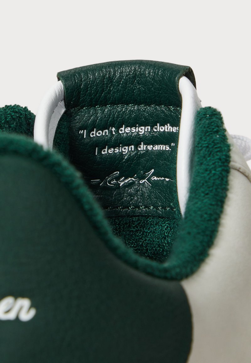 La linguetta verde in pelle della sneaker presenta una citazione in bianco e una firma su uno sfondo testurizzato, con una morbida fodera verde.