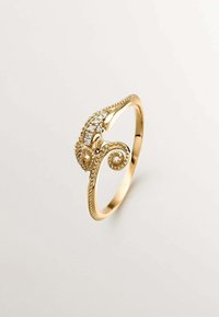 Anillo de oro con un intrincado diseño de pulpo. Presenta pequeñas piedras preciosas transparentes, detalles texturizados y una banda retorcida para un interés visual adicional.