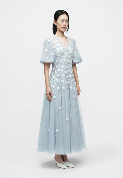 Ljusblå tyllklänning med blommig brodyr, korta puffärmar, V-ringning och golvlång kjol. Dekorerad med paljetter.