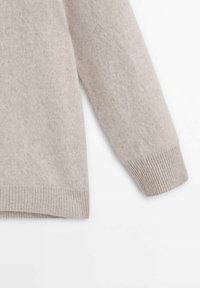Ljust grått kashmirtröja med ribbad nederkant och muddar, med en mjuk textur och avslappnad passform. Enkelt, utan utsmyckningar.