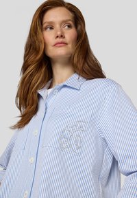 Blau-weiß gestreiftes Hemd mit Knopfleiste, einer Brusttasche und Strassdetails, aus einem leichten Stoff gefertigt.