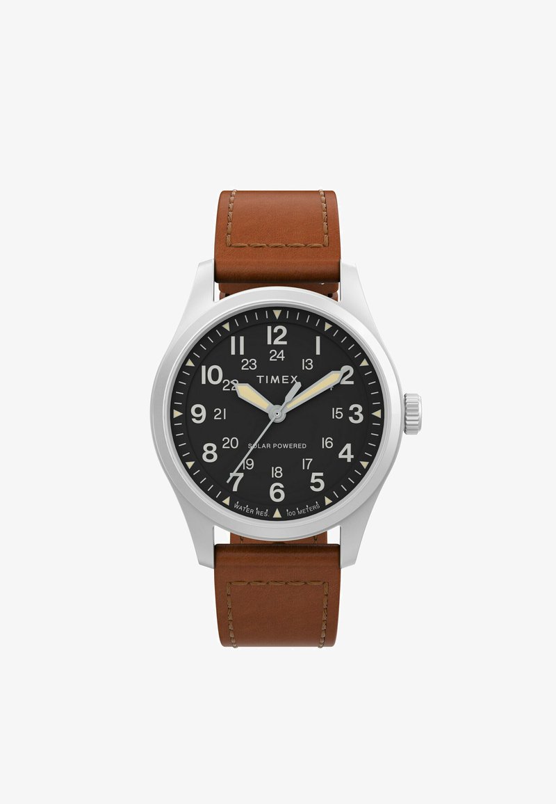 Ceasul solar Timex are un cadran negru cu numerale albe, carcasă din oțel inoxidabil și o curea din piele maro cu cusături vizibile.