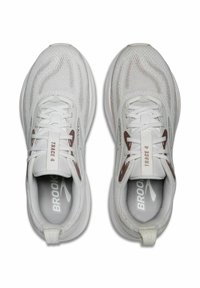 Weiße Sportschuhe mit einem Obermaterial aus Netzgewebe, Schnürsenkeln und braunen Akzenten. Entworfen mit "TRACE 4" Branding auf der Zunge und den Innensohlen.