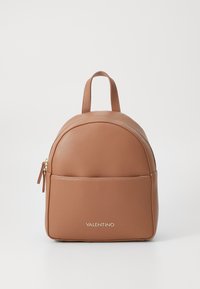 Kožený batoh světle hnědé barvy se strukturovaným povrchem, má zaoblený tvar, horní rukojeť, přední kapsu na zip a zlatý detail loga na spodní části přední strany.