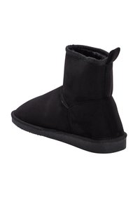 Botín negro hecho de suave ante sintético con una suela de goma gruesa y texturizada. Cuenta con una puntera redondeada y un caña corta y plegable.