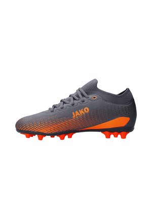 Grijze en oranje JAKO voetbalschoen met veters, oranje noppen en een gestructureerd ontwerp langs de zijkant.