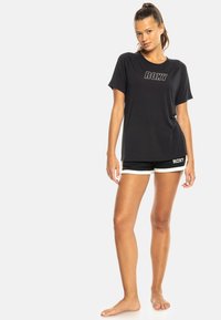 Czarny t-shirt Roxy z krótkim rękawem, z kontrastującym logo. W połączeniu z czarnymi szortami z białymi lamówkami i akcentem logo.