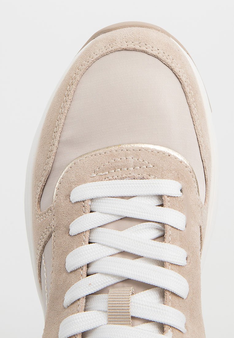 Helle beigefarbene Sneaker mit einem Obermaterial aus Wildleder und Nylon. Verfügt über weiße Schnürsenkel, einen gepolsterten Schaft und eine strukturierte weiße Sohle.